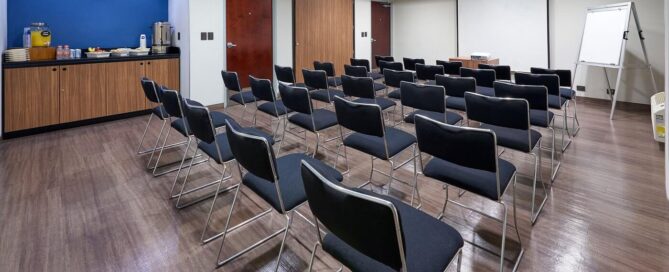 Sala de presentaciones con proyector y sillas individuales
