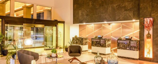 Lobby de Gamma Ciudad Juárez con área de descanso moderna.