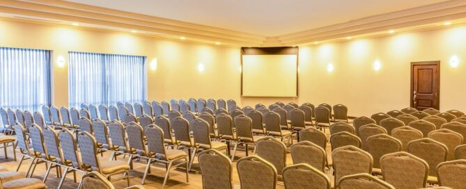 Salón Candilejas con montaje tipo auditorio, filas de sillas muy cómodas y pantalla de proyección, ideal para conferencias.