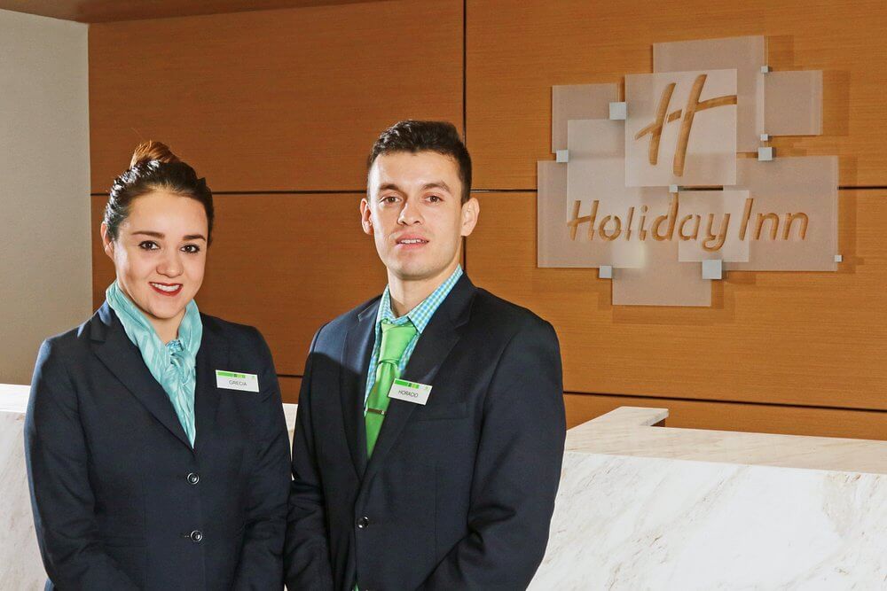 Holiday Inn – front desk Holiday Inn – Front Desk con personal atendiendo
