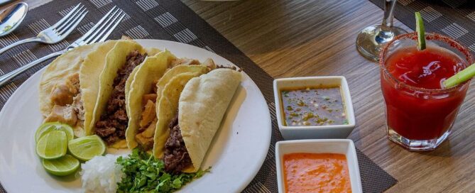 Hotel Lucerna Ciudad Juarez – tacos con salsas y limón servidos en restaurante, bebida al lado.