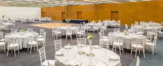Salón de eventos del Real Inn Ciudad Juárez montado en banquete con sillas tiffany y techo de luminarias.