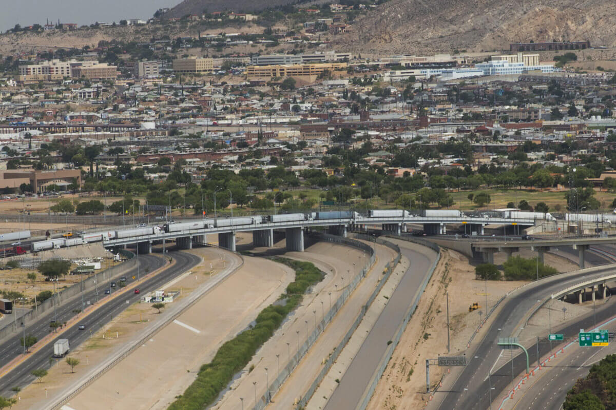 Vista aérea del Puente Internacional Córdova–Las Américas (BOTA, Puente Libre) con filas de tráileres cruzando sobre el canal del Río Bravo hacia El Paso.