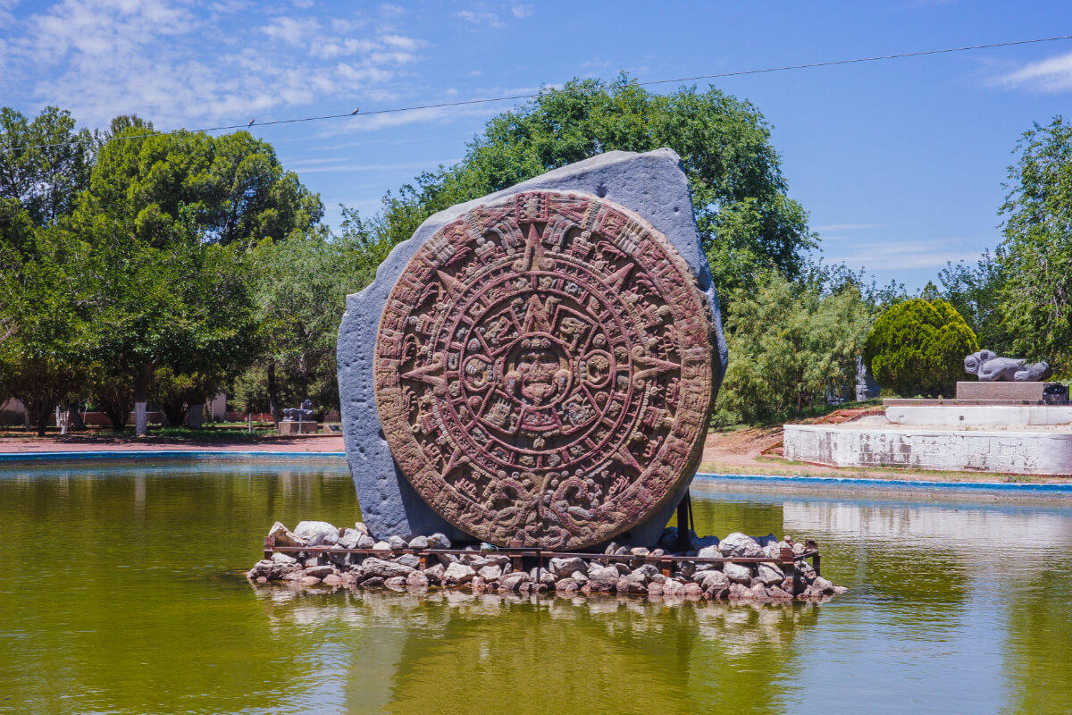 Calendario azteca monumental sobre una base en medio de un lago, en los jardines del Museo de Arqueología e Historia de El Chamizal, Ciudad Juárez.
